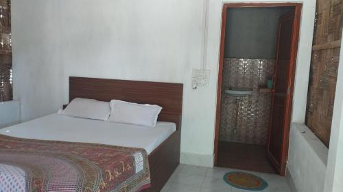 尼尔岛Blue Whale Resort and Restaurant的一间带一张床和淋浴的小卧室
