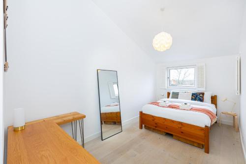 伦敦Stylish 1BR apt, 7min Archway Tube & Holloway Rd的一间卧室配有一张床和镜子