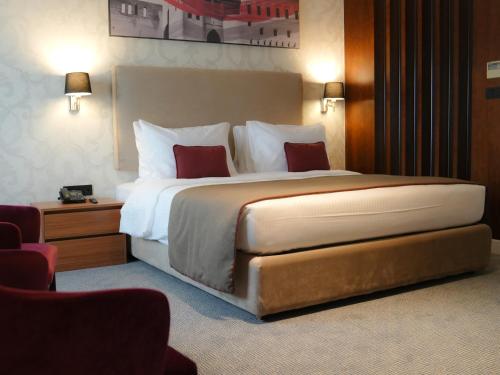 埃尔比勒Ramada Hotel & Suites by Wyndham Erbil 32 Park的一间位于酒店客房内的带大床的卧室
