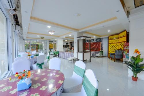 丹戎槟榔OYO 2487 Sampurna Jaya Hotel的宴会厅,配有桌椅