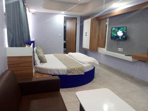 NarodaHotel Red Blue,Ahmedabad的一间设有床铺和墙上电视的房间