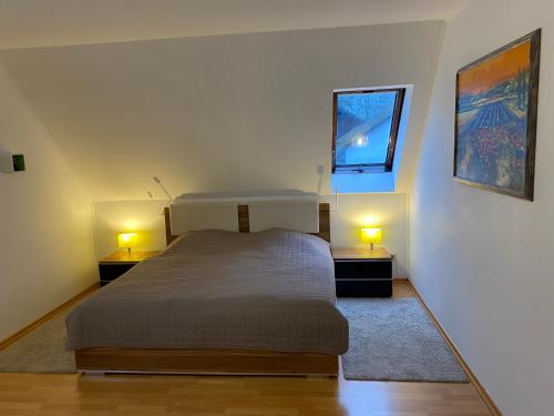 特罗斯多夫FeWo LaChristina Köln-Bonn-Siegburg的一间卧室配有一张床,两盏台灯放在两张桌子上