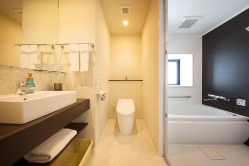 沼津静铁商旅Prezio 沼津的浴室配有盥洗盆、卫生间和浴缸。