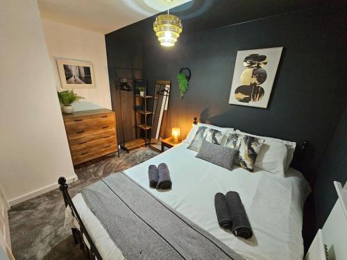 谢菲尔德Homebird Property - Waltz House的一间卧室配有一张大床和拖鞋