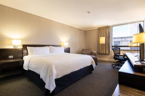 康塞普西翁康塞普西翁智选假日酒店的配有一张床和一张书桌的酒店客房
