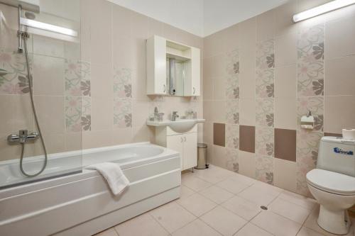 金沙Continental Apartments的带浴缸、卫生间和盥洗盆的浴室