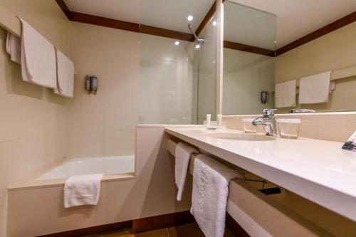 卡达克斯索尔艾克森特酒店的浴室配有盥洗盆和浴缸。