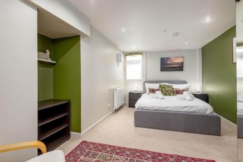 圣安德鲁斯Gibson Place - 15 Secs to The Old Course: Parking Nearby的卧室拥有绿色和白色的墙壁,配有一张床