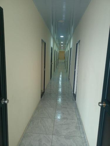 库库塔Hotel Arci的空的走廊,有门,铺着瓷砖地板
