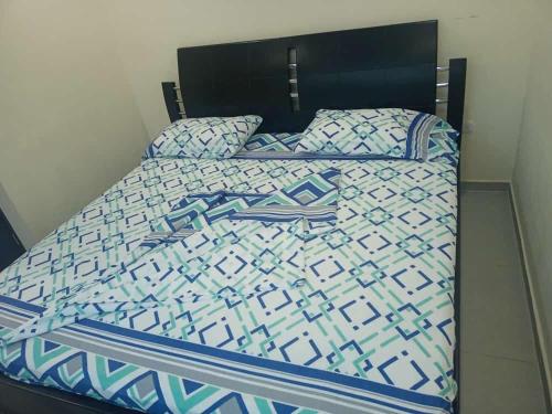 库库塔Hotel Arci的一张带蓝色和白色棉被和枕头的床