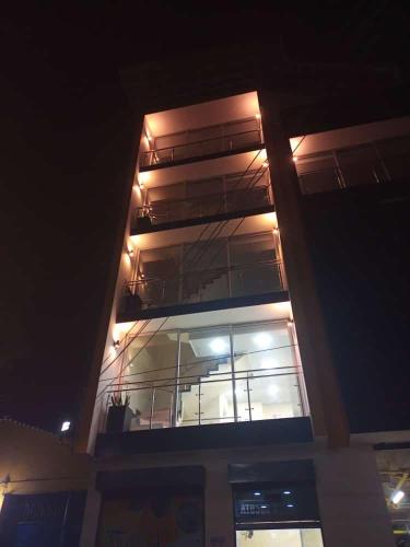 库库塔Hotel Arci的一座晚上有灯的建筑