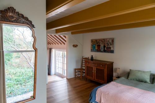 NigtevechtKleinhoef - charmante, luxe kamers in een boerderij uit 1875的一间卧室设有一张床和一个大窗户