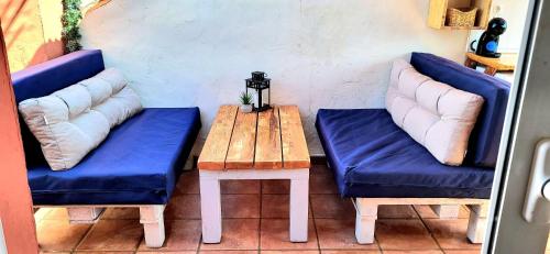 EsteponaSelwo Studio的两张蓝色的椅子和一张带长凳的木桌