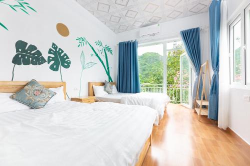 吉婆岛Cat Ba Countryside Homestay的配有蓝色窗帘的客房内的两张床