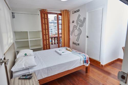 利马Hostel Prada的小房间设有一张床和一张桌子