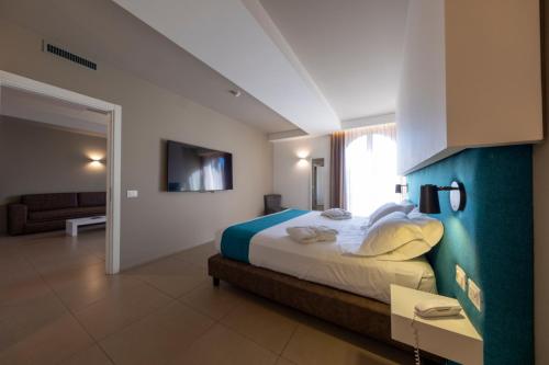 卡塔尼亚白鹭城大酒店 的一间卧室配有一张大床和一张沙发