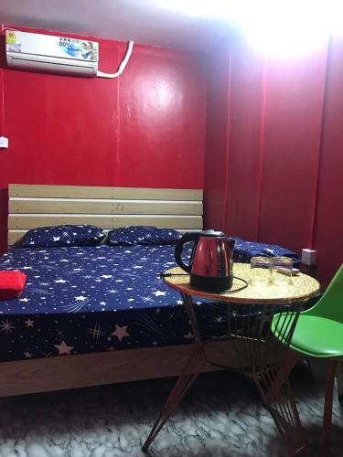 西哈努克The Big Boss Indian & Nepali Cuisines的一间卧室配有一张床、一张桌子和茶壶