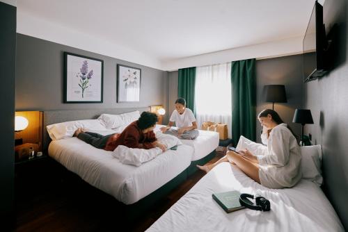 瓦伦西亚马尔科姆和巴瑞特酒店的一群人坐在酒店房间的床边