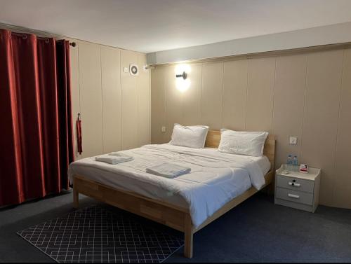 金边Whitehouse Guesthouse 2的卧室配有一张带白色床单和枕头的大床。