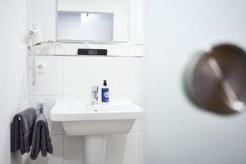 瓦雷尔Vareler Brauhaus-Hotel Varel Dangast的白色的浴室设有水槽和镜子