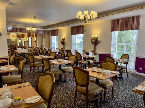 博格诺里吉斯皇家诺福克酒店的用餐室配有桌椅