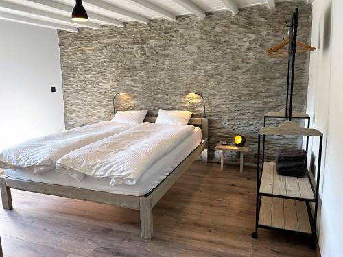 胡法利兹B&B Le Nid d'Hirondelle的一间卧室设有一张床和砖墙