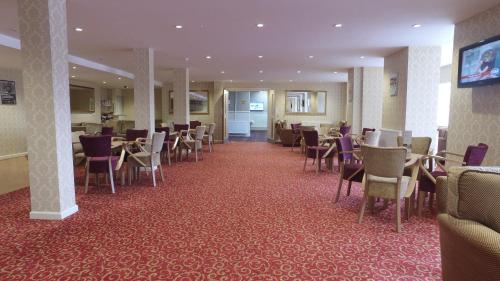 大雅茅斯新滩大酒店的一间设有桌椅的餐厅