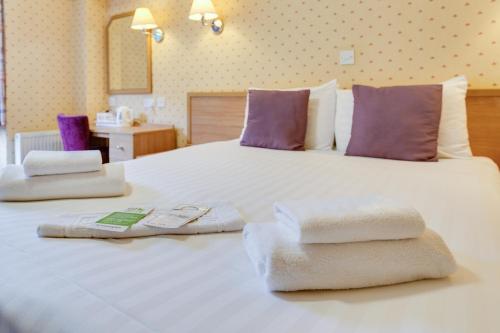 大雅茅斯新滩大酒店的卧室配有带毛巾的大型白色床
