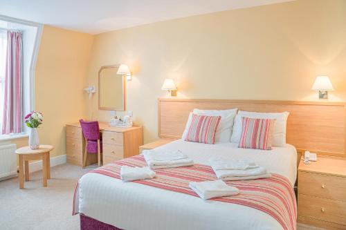 大雅茅斯新滩大酒店的一间卧室配有带毛巾的床