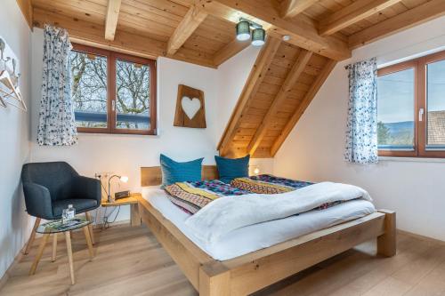 奥佩瑙Vorderbühlhof的一间卧室配有一张带蓝色枕头的床和一把椅子