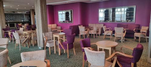 尚克林尚克林酒店的一间拥有紫色墙壁和桌椅的房间