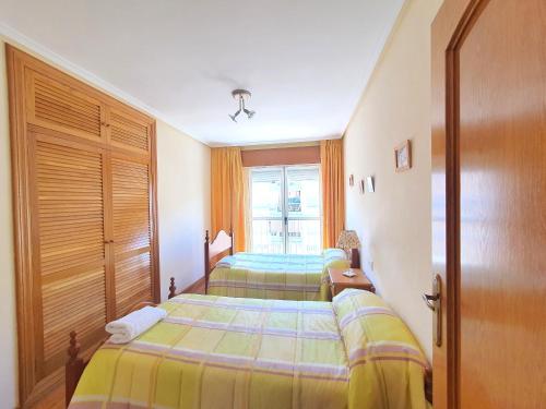 阿桂拉斯Playa de Poniente con Aire Acondicionado, Parking y Wifi - by Aloha Palma的一间卧室设有两张床和窗户。