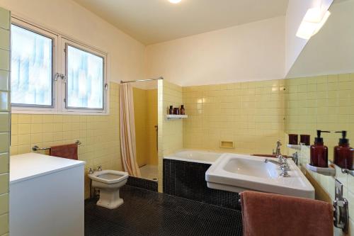 Rion-des-LandesVilla d’exception pour petites et grandes tribus的一间带水槽、浴缸和卫生间的浴室
