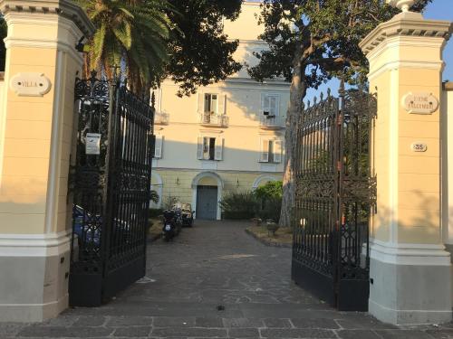 圣安吉洛Villa Falconieri Sorrento Suite的两扇门,一对门通往一座棕榈树建筑