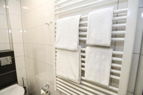 杜伊斯堡Sportschule Wedau的浴室提供挂在毛巾架上的白色毛巾
