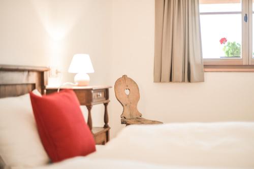 拉古多Tholer Ferienwohnung 2的一间卧室配有一张带红色枕头和桌子的床