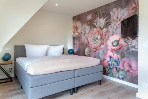 韦斯特兰Family Hüs的一间卧室配有一张带花卉墙壁的床