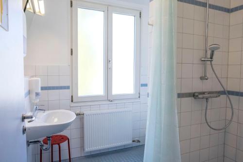 吕贝克吉格恩德尔贝尔格吕贝克沃尔德姆布尔格特尔酒店的一间带水槽和淋浴及窗户的浴室