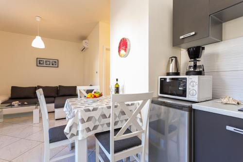 巴斯卡Apartment N4 D&D, Baska的厨房以及带桌子和微波炉的客厅。