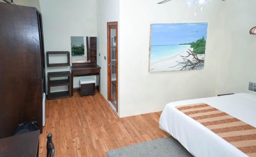 KelaaHoliday Home Kelaa Retreat的一间卧室配有一张床、一张书桌和一个窗户。