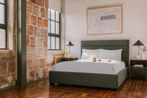 新奥尔良Sonder The Schaeffer的一间卧室设有一张床和砖墙