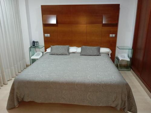奥维多Nap Oviedo的一间卧室配有一张大床和木制床头板