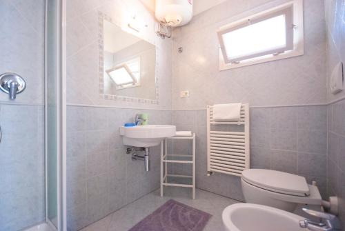卡波利韦里Camping Bungalow Lido的一间带水槽、卫生间和镜子的浴室