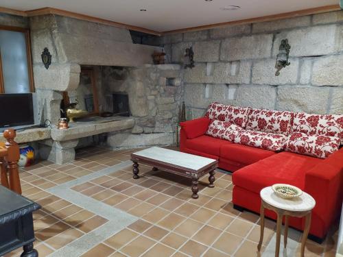 维戈Hotel O'Pazo的客厅设有红色的沙发和石墙