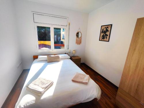 普拉加德阿罗Apartamento en el centro de Playa de Aro的卧室设有一张白色大床和一扇窗户。