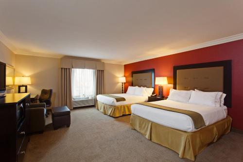 二十九棕榈村二十九棕榈村快捷假日&套房酒店的酒店客房设有两张床和红色的墙壁。