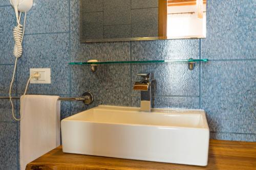 水晶湾Hotel Santo Stefano的浴室设有蓝色瓷砖,配有白色水槽。