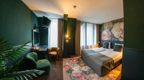 海尔伦Stadshotel Heerlen的酒店客房,配有床和沙发