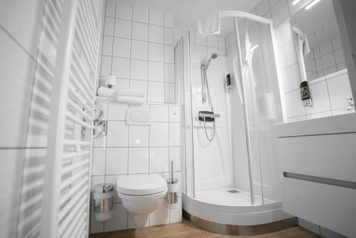 海尔伦Stadshotel Heerlen的带淋浴和卫生间的白色浴室