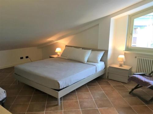 奥斯塔Appartamento Ottoz Aosta的一间卧室配有一张床、一个窗口和两盏灯。